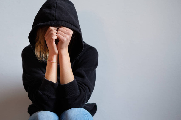 Szomorú tinédzser lány kapucnis fekete pulóver elszigetelt - Fotó, kép