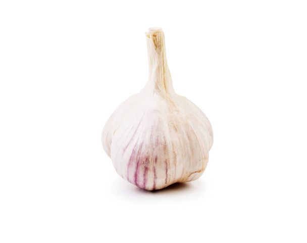 A close-up picture of a whole head of garlic, isolated on a white background. Natural ingredient full of healthy vitamins from a home orchard. Nutritious summer harvest. - Фото, изображение