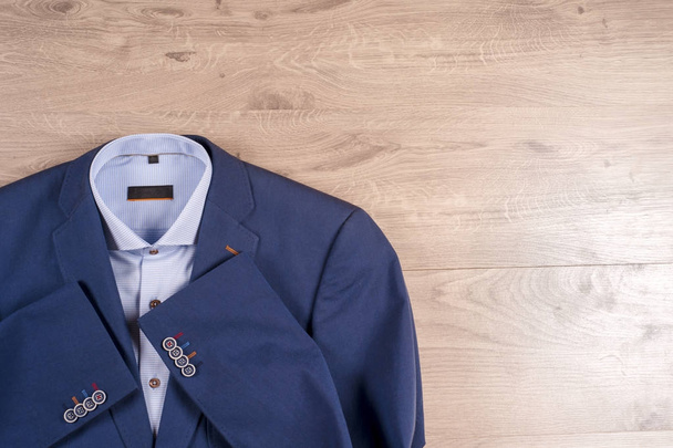 Klasik erkek kıyafetleri - mavi takım, gömlekler, kahverengi ayakkabılar, kemer ve kravat ahşap arka planda. - Fotoğraf, Görsel