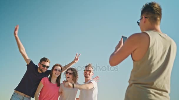 Νέους ανθρώπους που ποζάρουν για μια φωτογραφία στην παραλία - Πλάνα, βίντεο