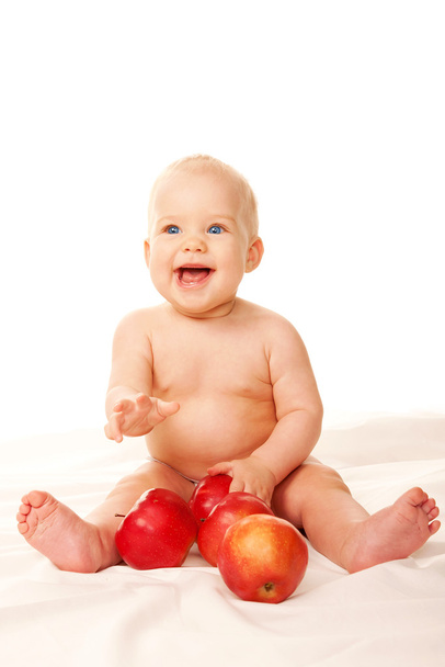 Дитина сміється з великими червоними яблуками
 - Фото, зображення