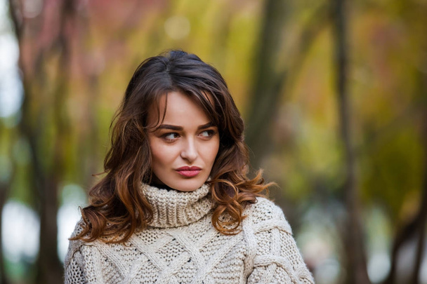 Beautiful emotional woman in an autumn park, looking away. - Valokuva, kuva