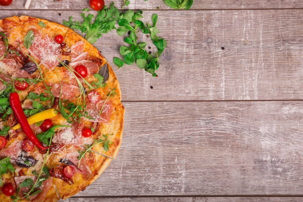 明るい熱いチリペッパーとイタリアのスパイシーな肉のおいしい apicollo ピザの上からの眺め。素朴な木製のテーブル背景においしい料理。料理、ベーキングのコンセプトです。コピー スペース. - 写真・画像