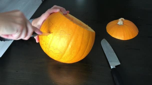 Female hands are carving a Halloween pumpkin - Footage, Video
