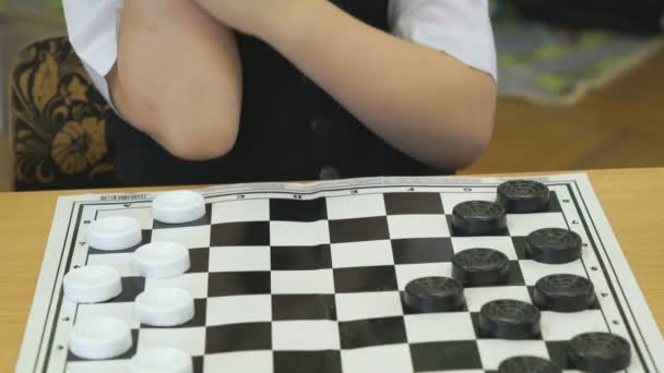 The child plays checkers in kindergarten indoors - Πλάνα, βίντεο