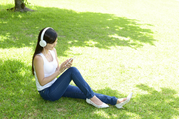 молода жінка розслабляється в парку
 - Фото, зображення