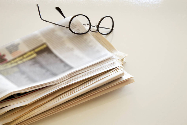 Newspaper with eyeglasses on brown background - Photo, Image