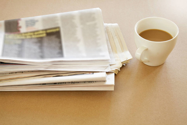 Newspaper with coffee on brown background - Фото, изображение