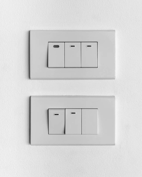 2 つの白いコンクリートの壁にトリプル照明スイッチのセット - 写真・画像