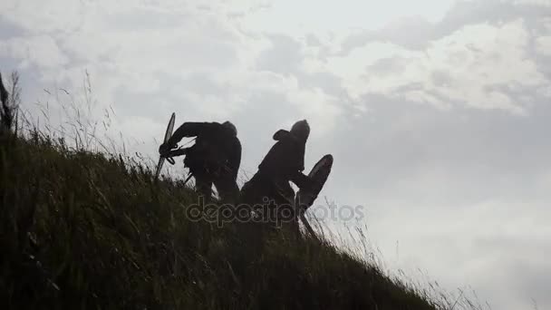 Silhouetten zweier Wikinger kämpfen mit Schwertern und Schilden. - Filmmaterial, Video