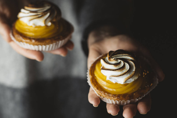 Lemon pie in woman hands. Traditional french sweet pastry tart. Delicious, appetizing, homemade dessert with lemon cream. Copy space, closeup. Selective focus. Toned - Φωτογραφία, εικόνα
