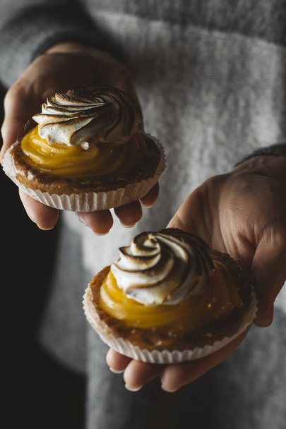 Zitronenkuchen in Frauenhand. traditionelle französische Süßgebäcktorte. lecker, appetitlich, hausgemachtes Dessert mit Zitronencreme. Kopierraum, Nahaufnahme. Selektiver Fokus. gemildert - Foto, Bild