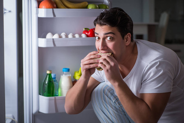 Buzdolabındaki adam gece yemek yiyor. - Fotoğraf, Görsel