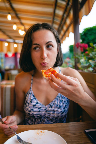 The girl is eating pizza. - Photo, Image
