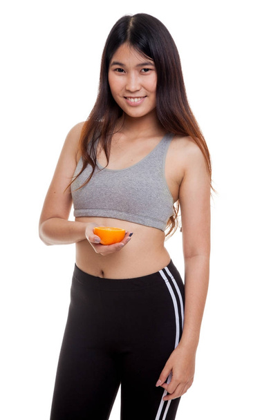Beautiful Asian healthy girl with orange fruit. - Foto, Imagen
