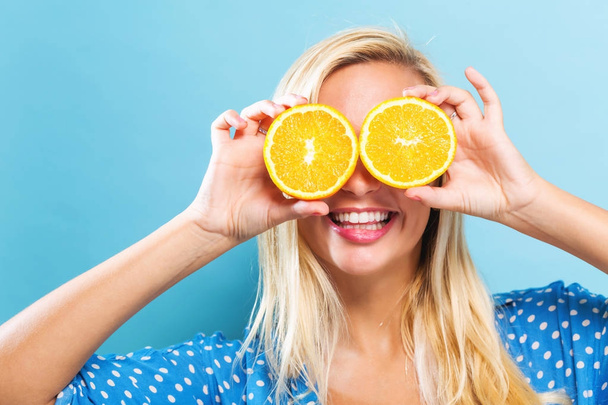 Happy young woman holding oranges  - Фото, изображение