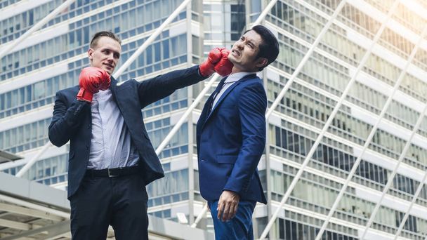 dois homens de negócios estão lutando com luva de boxe na cidade ao ar livre
 - Foto, Imagem