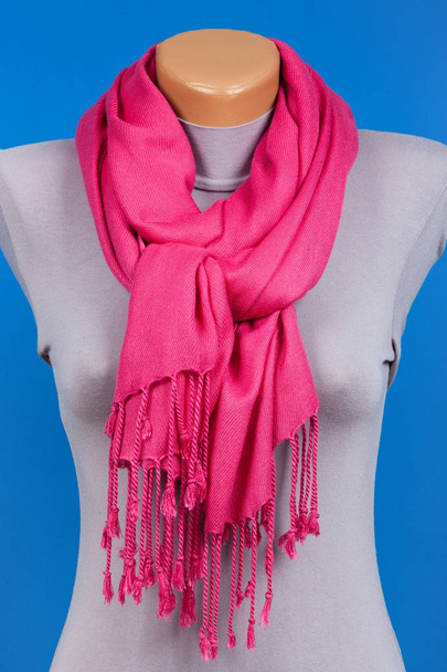 Roze sjaal op etalagepop geïsoleerd op blauwe achtergrond. - Foto, afbeelding