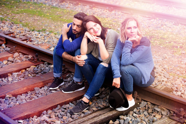three friends sitting on train tracks and enjoying the sun - Foto, Imagem