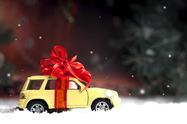 piccola auto con fiocco decorativo sulla neve
 - Foto, immagini