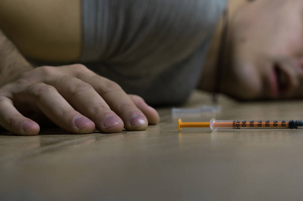 La mano del adicto está acostada en el suelo después de tomar la dosis. Muerte de un drogadicto
 - Foto, Imagen