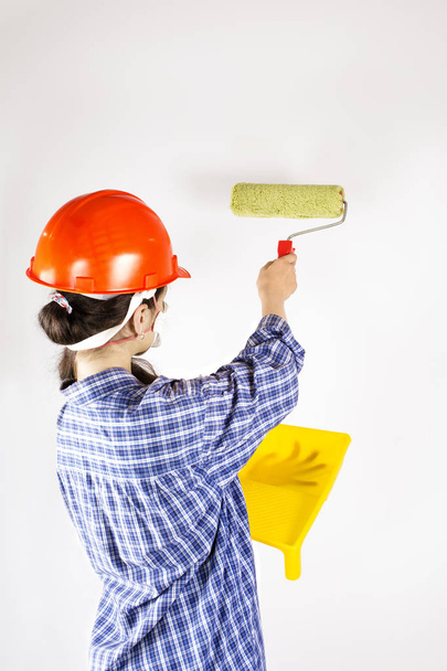 Female worker painting wall with paint roller - Foto, Bild