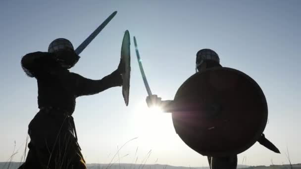 Sziluettek a vikingek harcosok harcol karddal, pajzs. Contre-jour - Felvétel, videó