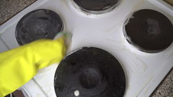 Gospodyni czyścić kuchenka elektryczna w rękawice żółty. - Materiał filmowy, wideo