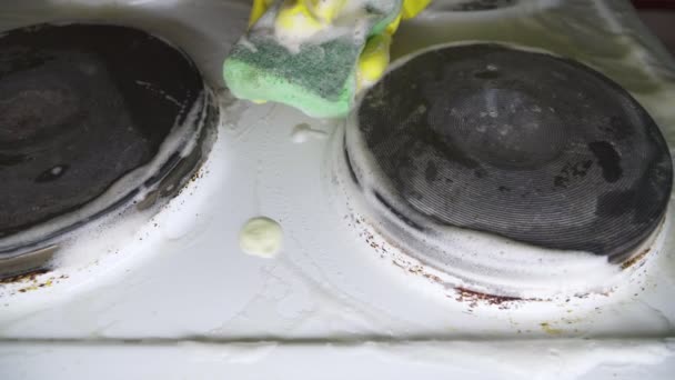 Gospodyni czyścić kuchenka elektryczna w rękawice żółty. - Materiał filmowy, wideo