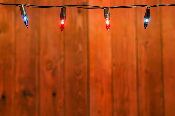 Χριστουγεννιάτικα φωτάκια πάνω σε ξύλινα φόντο προβολή με αντίγραφο χώρου - Φωτογραφία, εικόνα