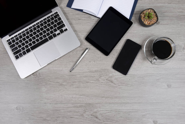 Office tabulka s přenosný počítač, notebook, digitální tabletu, pera, smartphone, myší a kávy na bílém pozadí. Stolní office maketa koncept. - Fotografie, Obrázek