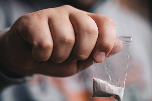 Дилер наркотиків, що дає або продає пакет з героїном, кокаїном або іншим порошковим наркотичним, селективним фокусом
 - Фото, зображення