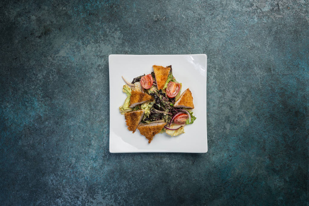 Паназийский салат, овощи с жареной курицей. На квадратной белой тарелке. Вид сверху
 - Фото, изображение