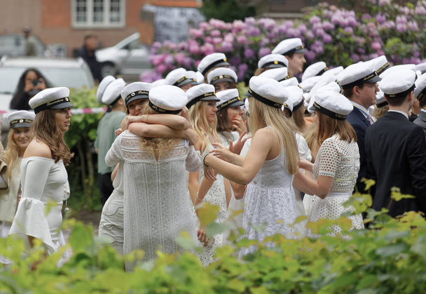 Στοκχόλμη, Σουηδία - Ιούνιος 13, 2017: Happy Swedish teens wearing graduation caps hooking each other after graduation at the dance school Balettakademien, Ιούνιος 13 2017, Στοκχόλμη, Σουηδία - Φωτογραφία, εικόνα
