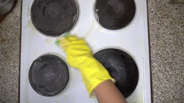 Huisvrouw schoon de elektrische kookplaat in gele handschoenen. - Video
