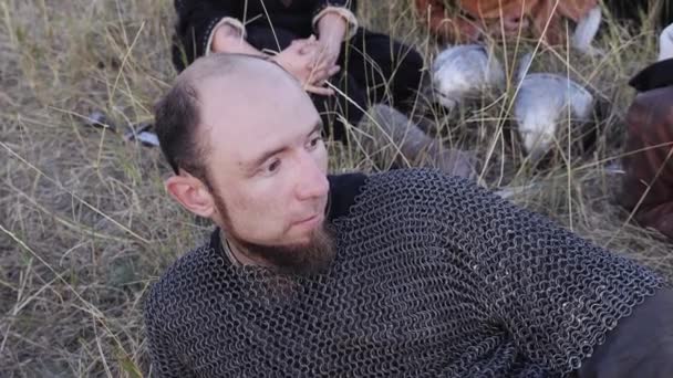 Porträt eines Wikingers in Kettenhemd, der im Gras liegt - Filmmaterial, Video