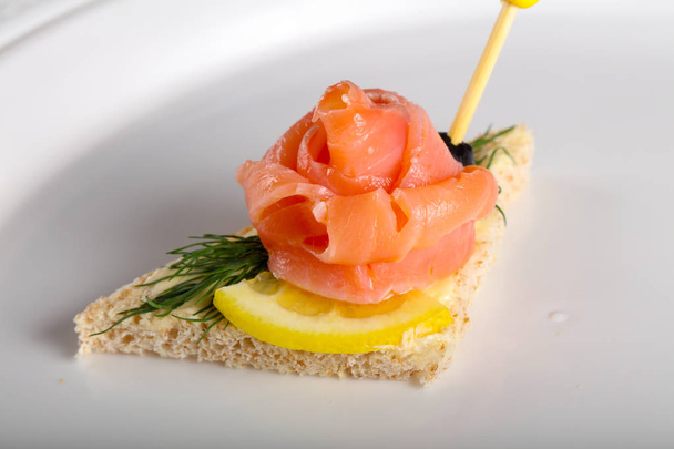 Sandwich con salmón en plato
 - Foto, Imagen