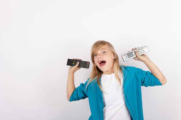 Cheerful girl showing remote controls - 写真・画像