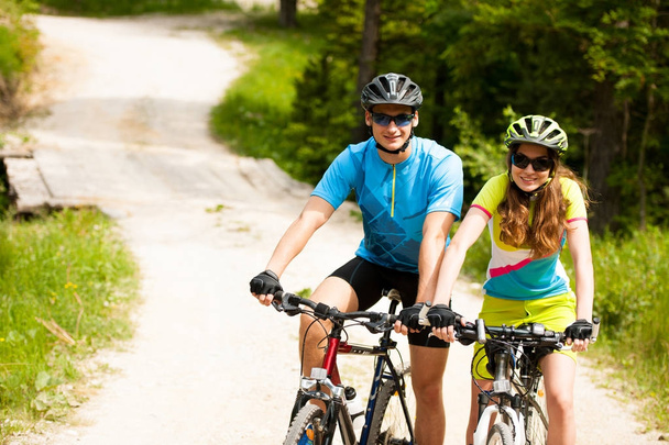 ACTIF Jeune couple faisant du vélo sur une route forestière en montagne en spr
 - Photo, image