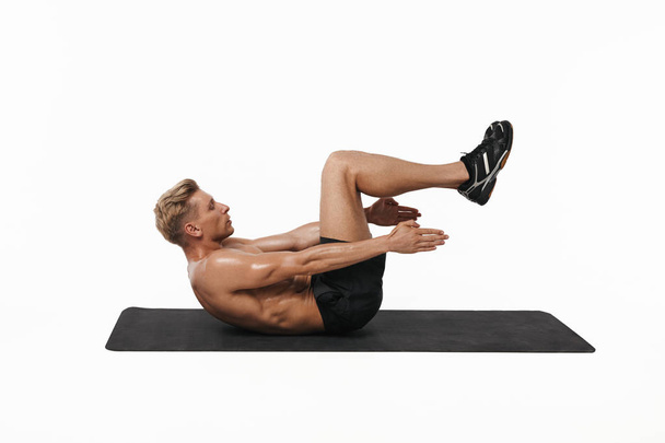 Man doing abs exercise in studio - Fotó, kép
