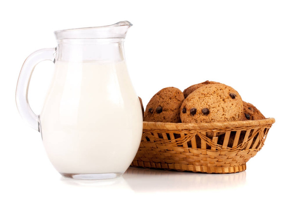 jug of milk with oatmeal cookies in a wicker basket isolated on white background - Photo, Image