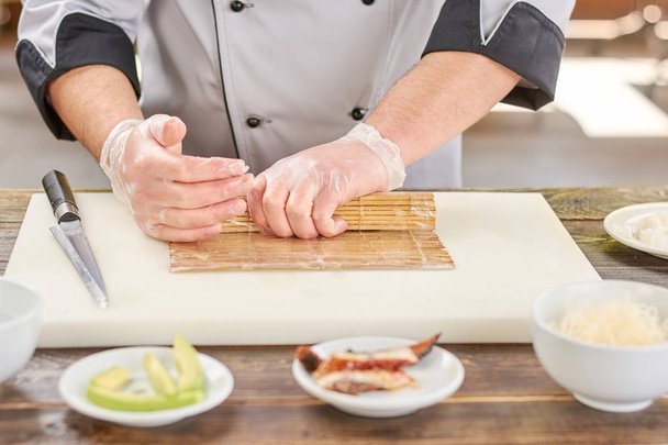 Mani di chef che modellano il rotolo di sushi
. - Foto, immagini