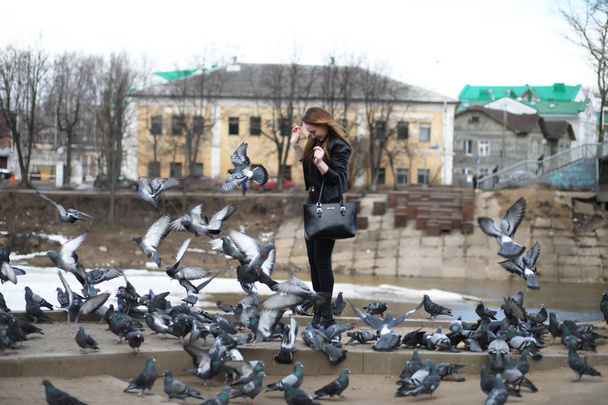 Dziewczyna na spacerze po parku i stado gołębi - Zdjęcie, obraz