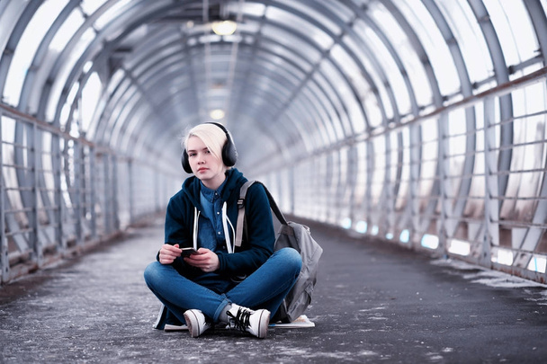 Joven estudiante escuchando música en grandes auriculares en el metro
 - Foto, imagen