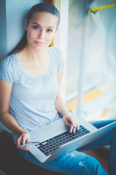 Young beautiful woman using a laptop computer at home. Young beautiful woman. - Photo, Image