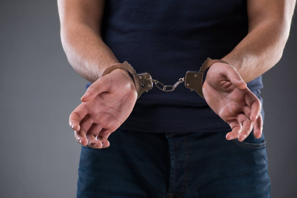 Man with his hands handcuffed in criminal concept - Foto, imagen