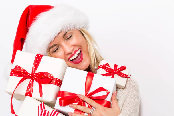 Woman with santa hat holding gift boxes - Foto, Bild