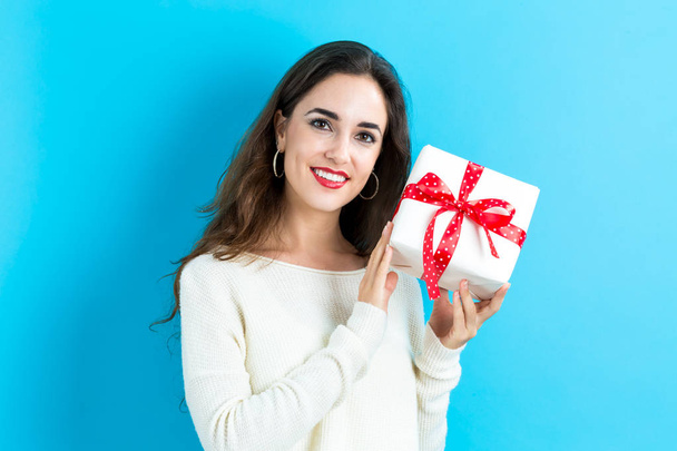 Young woman holding a gift box - Zdjęcie, obraz