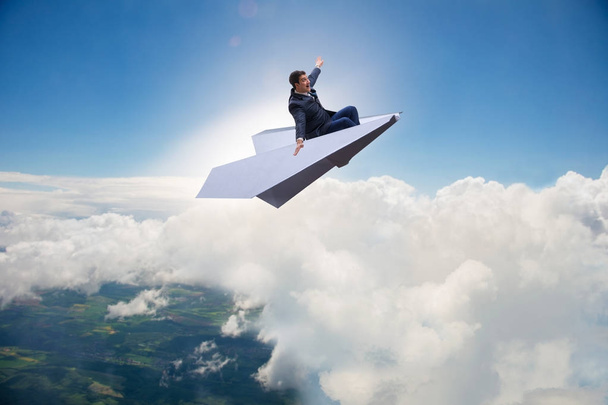 Homme d'affaires volant sur avion en papier dans le concept d'entreprise - Photo, image