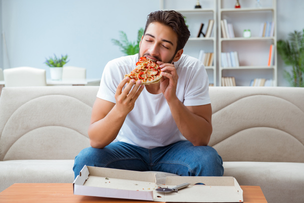 Mann isst Pizza zum Mitnehmen und ruht sich aus - Foto, Bild